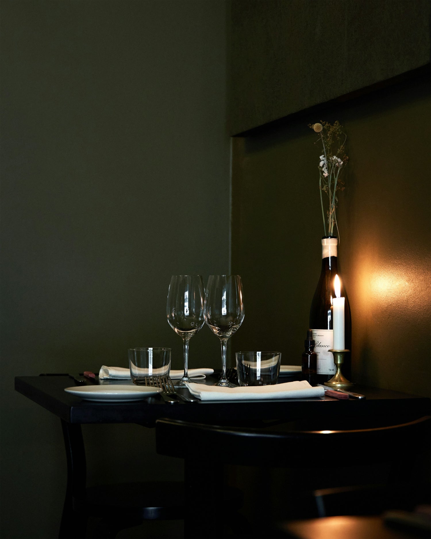 Gedeckter Tisch für zwei mit Wein und Kerzen – Gastgeber-Moment